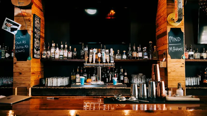 Carte de fidélité bar : comptoir d'un bar de quartier avec ses bouteilles et son ardoise